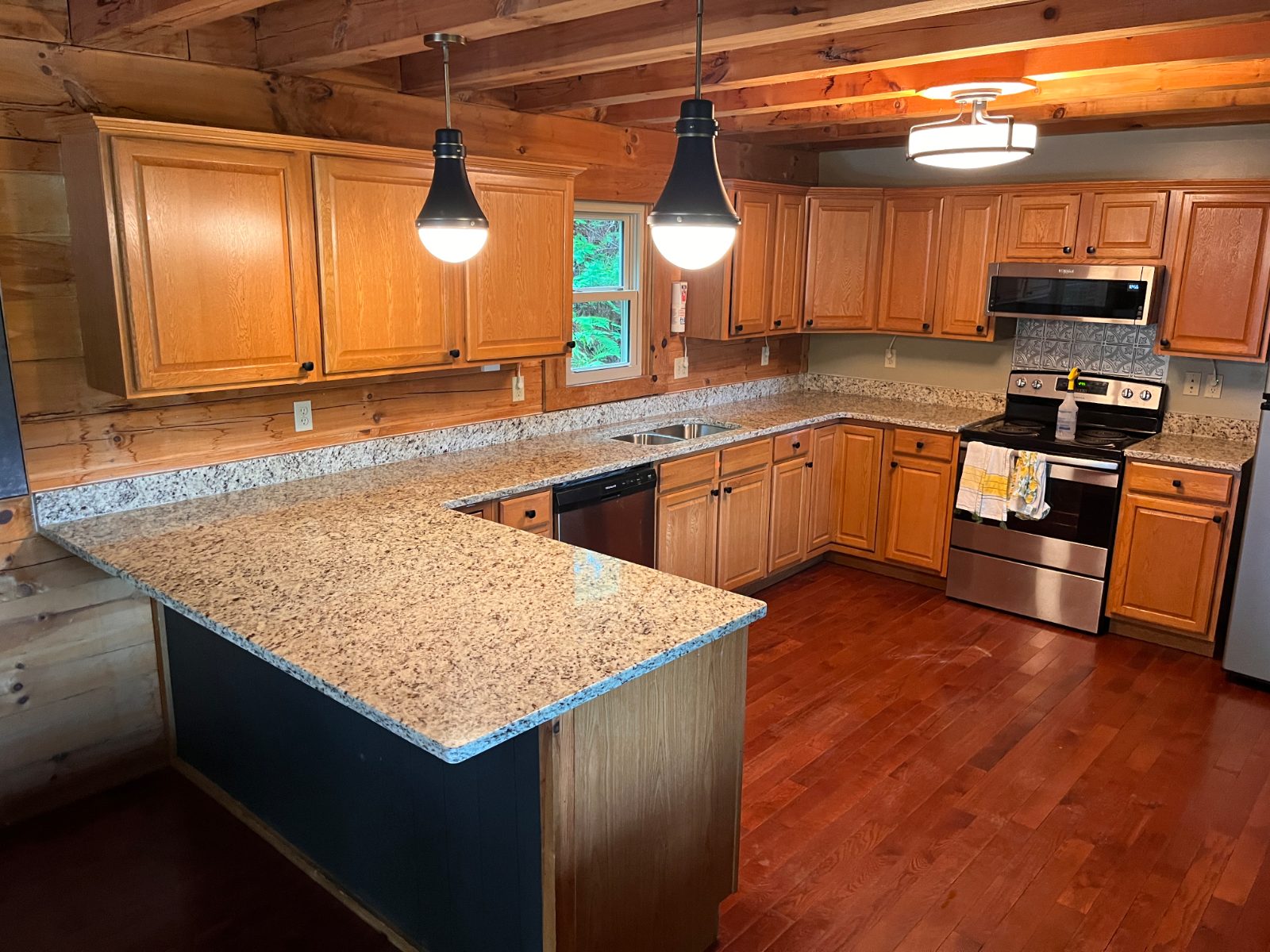 Ornamental Guidoni kitchen countertop installed in Bryson City, NC: U-shaped kitchen with a peninsula, double sink and range under pendant lights