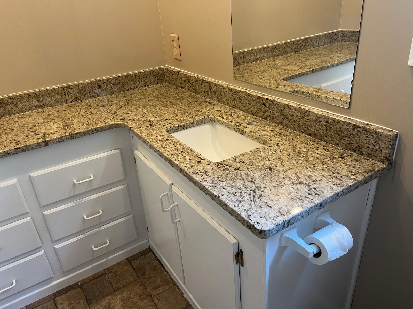 Ornamental Guidoni bathroom vanity countertop installed in Franklin, NC: L-shaped bathroom vanity with an undermount sink and full backsplash