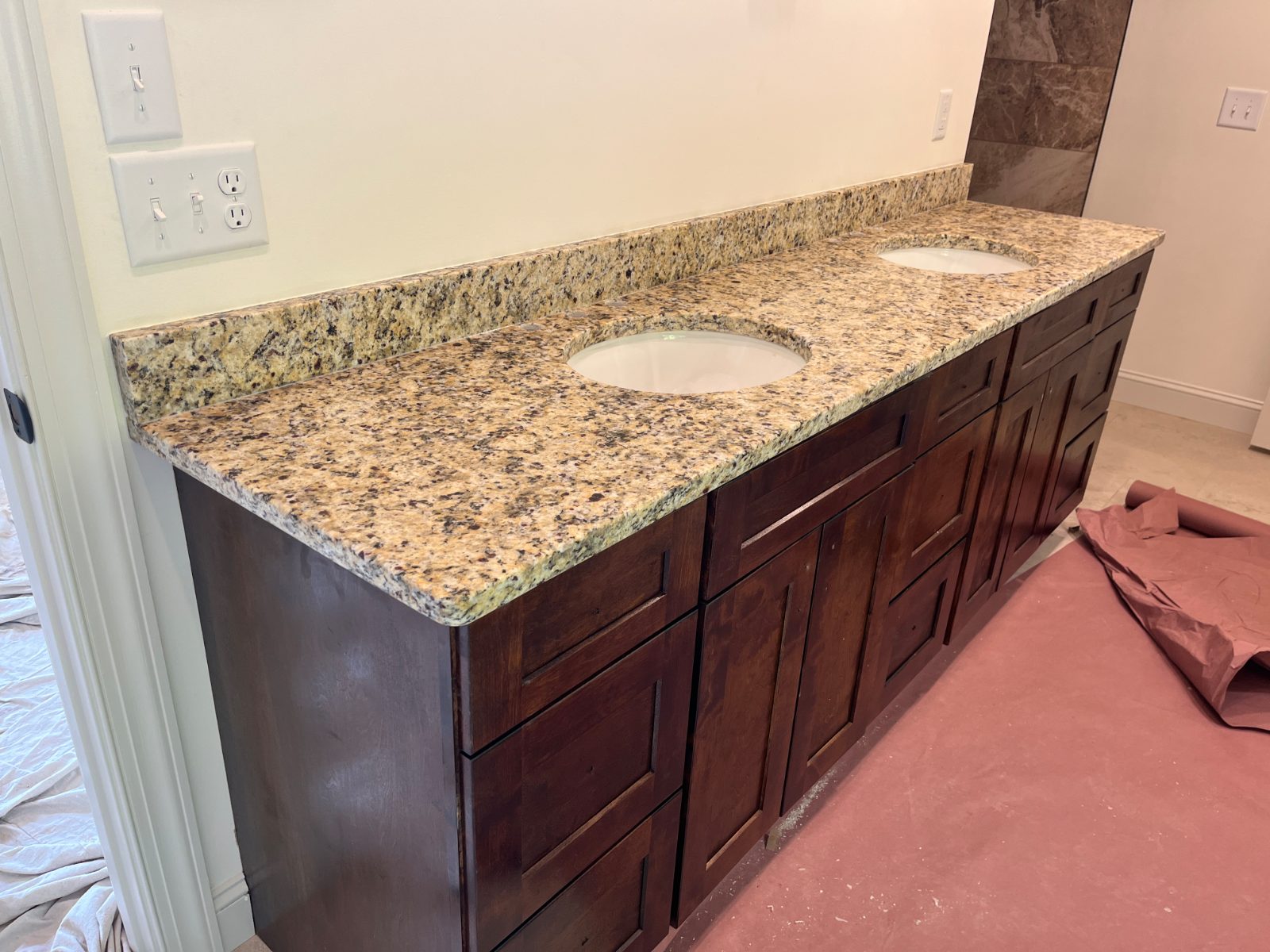 Giallo Napoli bathroom vanity countertop installed in Hayesville, NC: Double bathroom vanity with two undermount oval sinks and a backsplash
