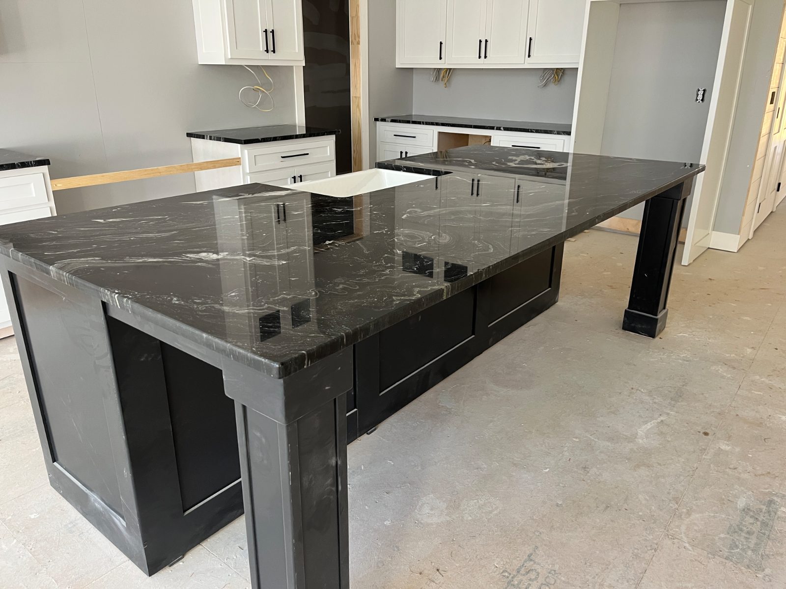 Kitchen countertop installed in Ivy Log, GA: Large island with farmhouse sink, end leg and perimeter cabinet runs