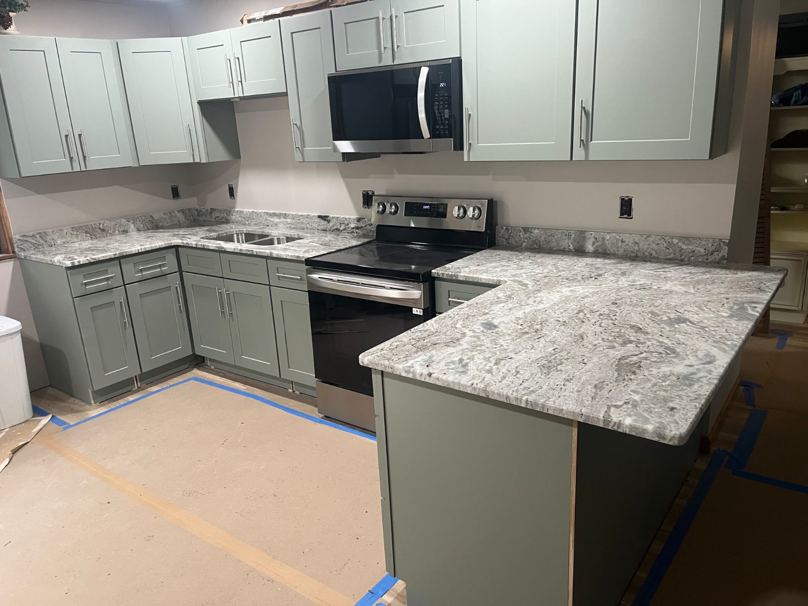 Fantasy Brown kitchen countertop installed in Murphy, NC: L-shaped kitchen with peninsula, undermount double sink and electric range