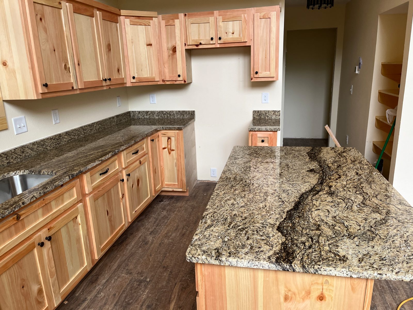 Ornamental Guidoni kitchen countertop installed in Murphy, NC: Large island beside an L-shaped run with undermount sink