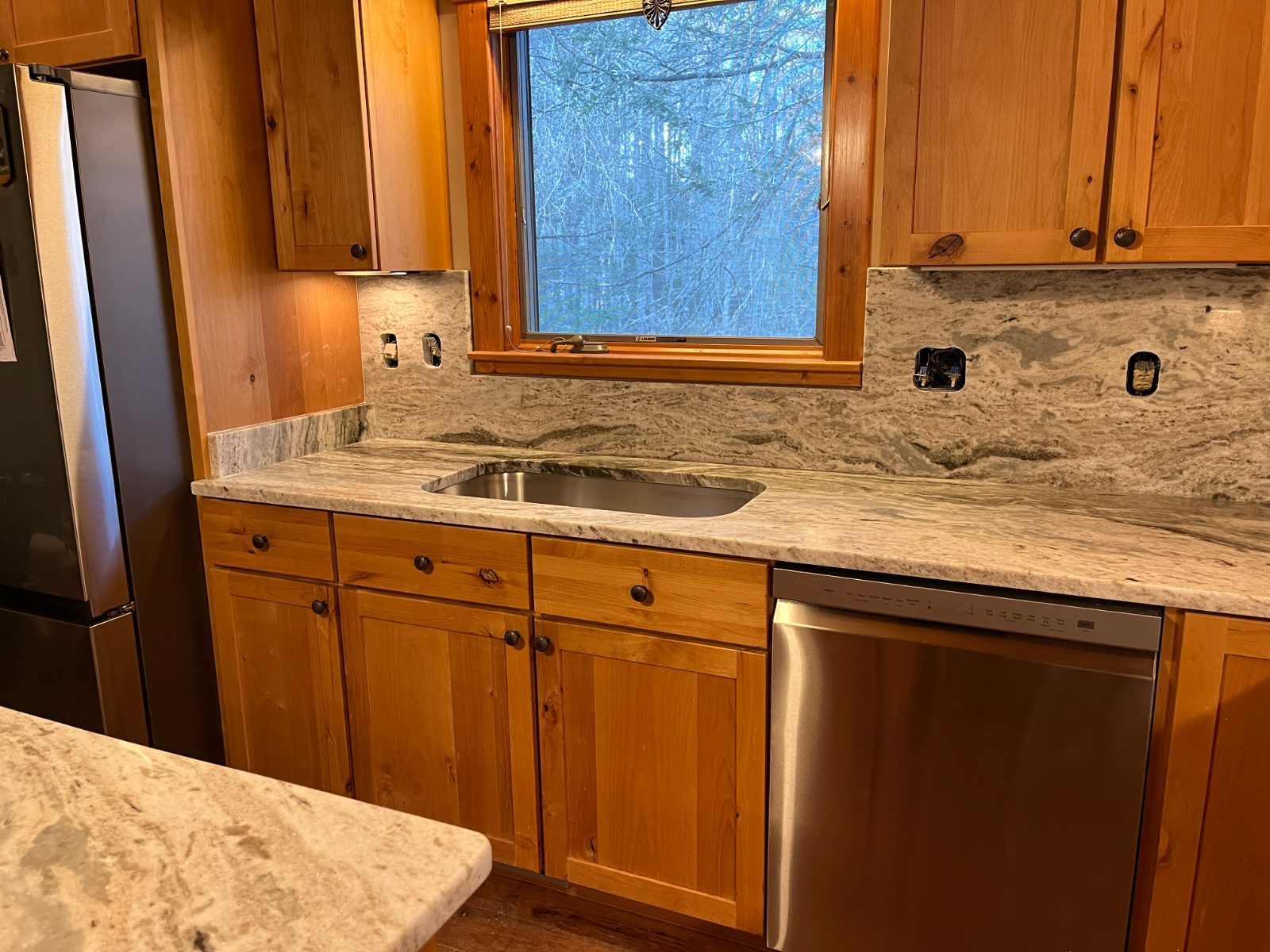 Fantasy Brown kitchen countertop installed in Murphy, NC: Sink run with undermount sink, full-height backsplash, dishwasher and island corner