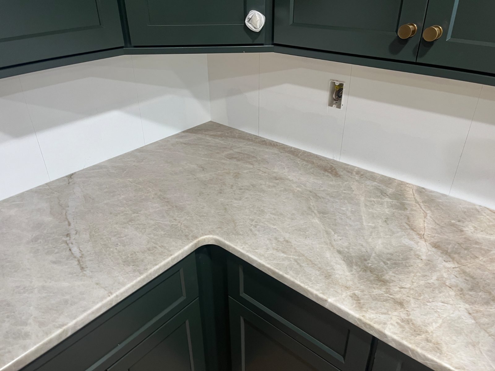 Taj Mahal kitchen countertop installed in Sylva, NC: L-shaped corner counter with an eased edge beneath shaker upper cabinets