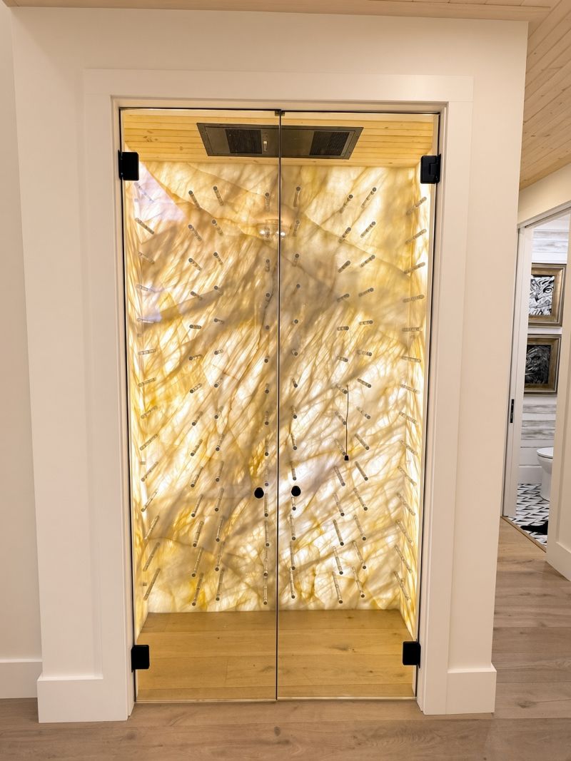 Backlit Cristallo quartzite feature wall in a glass-front wine room