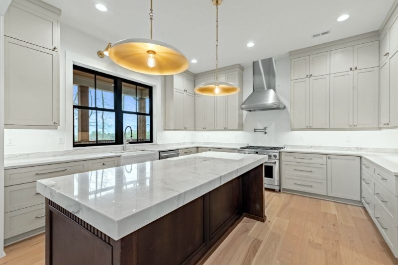 Bianco Superior quartzite island on a dark wood base in a bright kitchen